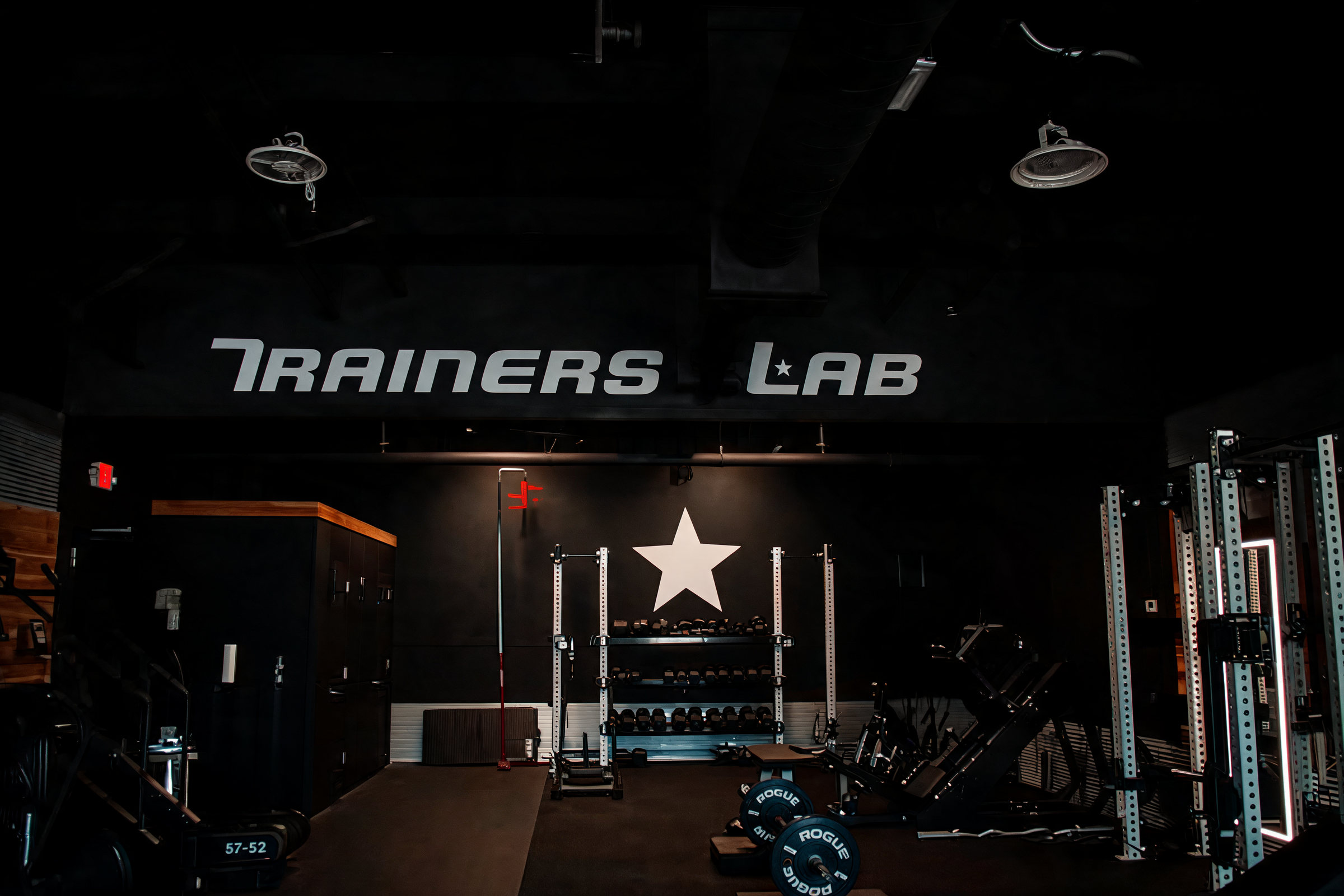 The TrainersLab Mount Juliet training floor, with squat racks, dumbbells and the TrainersLab star wall